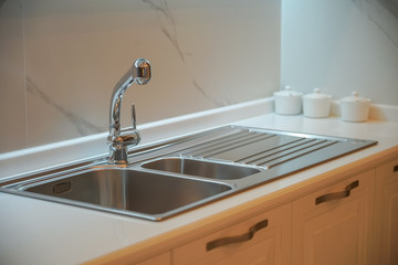 Stainless sink / washbasin and faucet on a modern kitchen countertop.