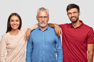 Multi generation concept. Family portrait of mature wrinkled man dressed in stylish shirt, stands...