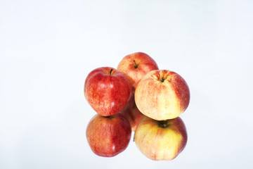 Three apples on table with reflection. Autumn abstract photo