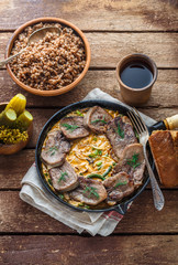 Beef tongue in cast iron skillet with cream sauce, rustic style.