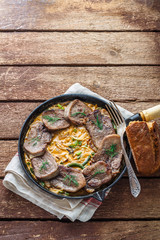 Sliced beef tongue in cast iron skillet, copy space