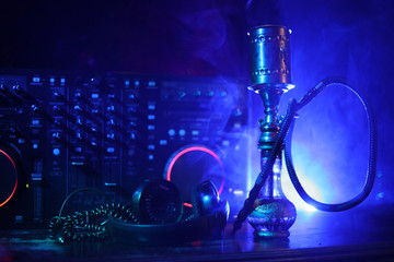 Shisha party club concept. Dj mixer with on dark nightclub background with stylish oriental shisha.