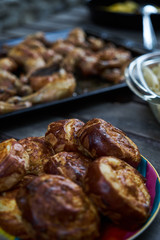 Party snack food table with baked potatoes, fried chicken drumsticks, italian pasta and puff pastry buns bread, close-up. Table with variety food top view. 