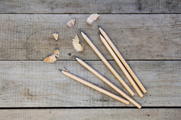 Pencils and shavings on wooden table.