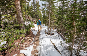 Obraz premium Tourist with backpack hiking on snowy trail