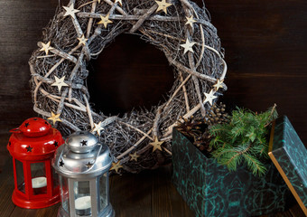red lantern , green box with branches of fir tree and christmas wreath on the wooden background. New year and christmas home decor, celebration concept
