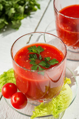 Fresh tomato juice with tomatoes and greens.