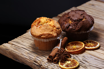 Chocolate muffin and nut muffin, homemade bakery on wooden background.
