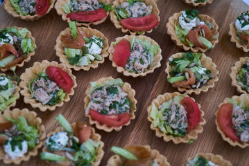 Delicious crispy tartlets or cake tarts  with cream cheese and vegetables, top view, close-up