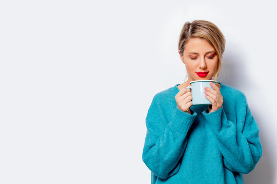 Portrait Of A Beautiful White Smiling Woman In Blue Sweater With Cup Of Coffee On White Background, Isolated.