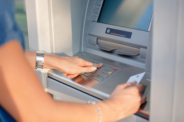 Close-up Of Person Using Credit Card To Withdrawing Money From ATM Machine