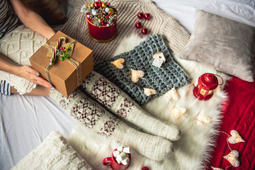 Top view female holding present in hands. Garland and cup of marshmallow locating near her