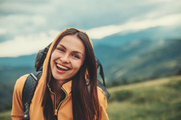 Overjoyed smiling young woman expressing positivity while resting in the mountains