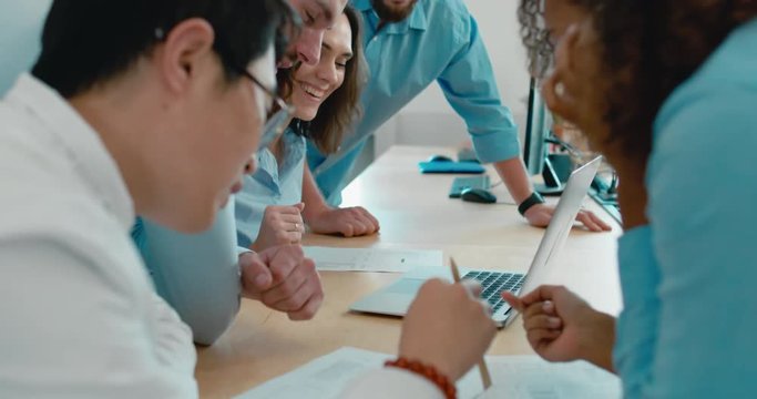 Large multi racial team of office workers communicating together and discussing a project on a computer screen. 4K UHD 60 FPS SLOW MOTION