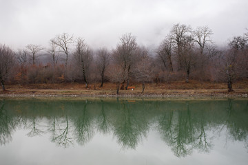 Landscape with misty morning fog in the Forest Lake or Beautiful forest lake in the morning at winter time. Azerbaijan nature.