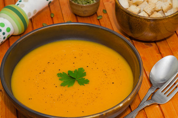 Homemade fresh pumpkin cream soup served with croutons