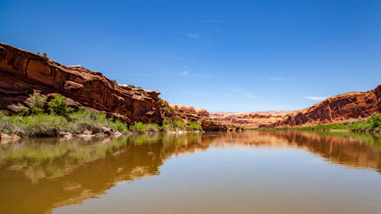 Fototapeta na wymiar Water view from the Colorado River along the bluffs and rock sculpture outside Moab, Utah