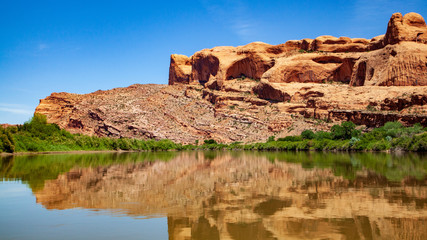 Fototapeta na wymiar Water view from the Colorado River along the bluffs and rock sculpture outside Moab, Utah