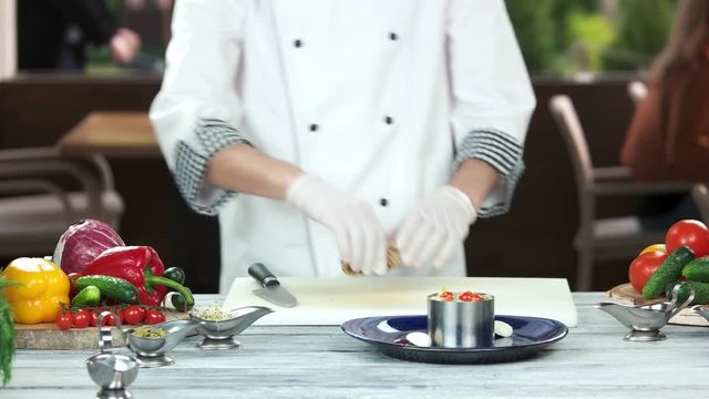Chef cutting salad ingredients. Quail egg and tuna.