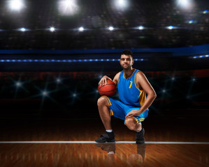 basketball player in blue uniform sitting on basketball court