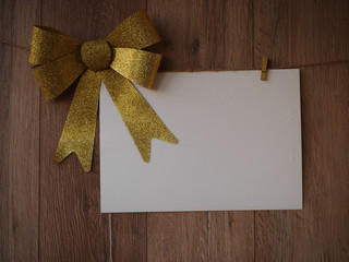 Bow Decorations with text space on white paper on a wooden background. Vintage greeting card. Holiday decorations and free space for text on a wooden background. Holidays decor card. Vintage texture.