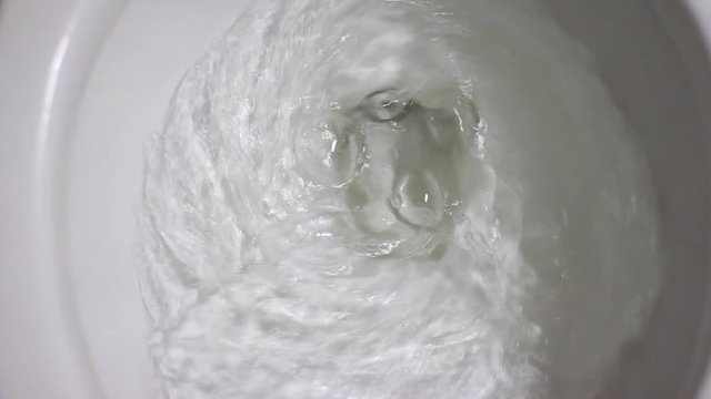 Press Cleaning toilet and flushed water in bathroom.