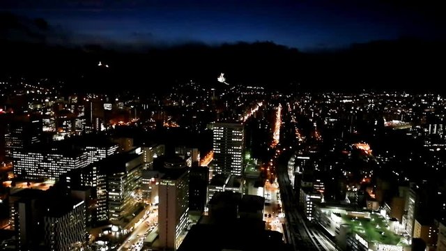Night aerial time-lapse in Sapporo Hokkaido during winter with moving cloud, cars and train
