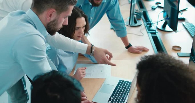 Large multi racial team of office workers communicating together and discussing a project on a computer screen. 4K UHD 60 FPS SLOW MOTION