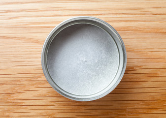 Metal can for tea packaging on wooden table, Top view.