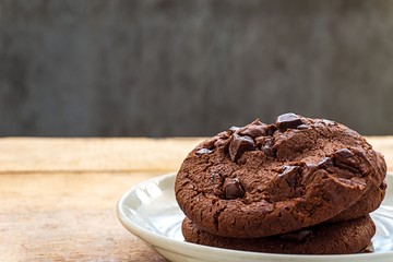 Close up picture of pile chocolate cookies in white plate