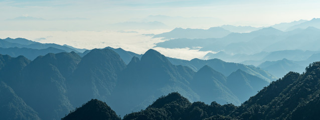 view of the far away mountain range covered in thick white cloud under hush sun light in the hazy morning - 225117399