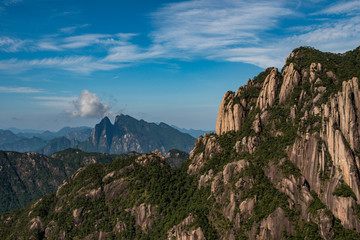 Naklejka premium green forest covered mount sanqing peaks under the cloudy blue sky