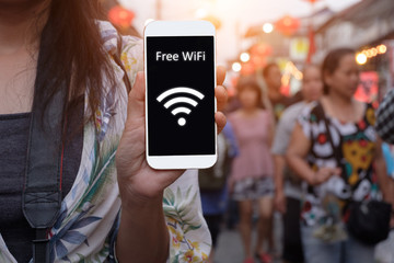 Girl is holding a white generic smartphone showing free WiFi.