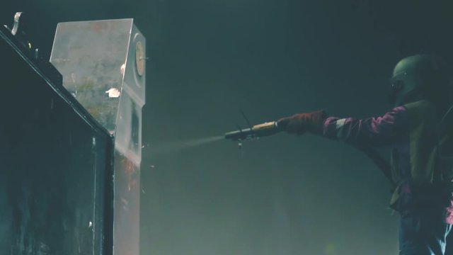 Man cleans metal surface by sandblaster gun in a metal construction factory. Shotblaster in a process