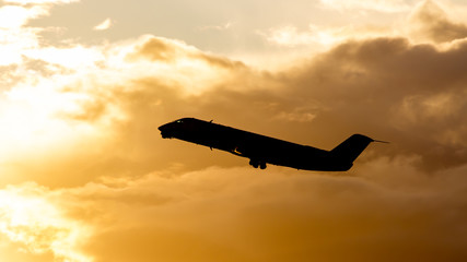 A flying airliner in the evening sky-a contour photography in the backlight. Contre-jour is a...