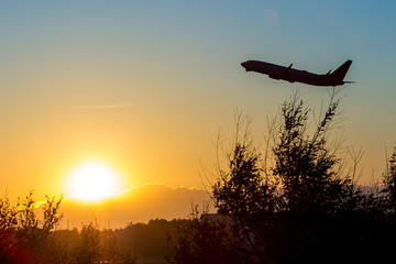 A flying airliner in the evening sky-a contour photography in the backlight. Contre-jour is a photographic technique in which the camera is pointing directly toward a source of light.