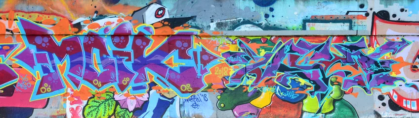 Fragment von Graffiti-Zeichnungen. Die alte Wand ist mit Farbflecken im Stil der Straßenkunstkultur dekoriert. Farbige Hintergrundtextur in violetten Tönen © mehaniq41