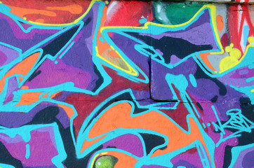 Fragment of graffiti drawings. The old wall decorated with paint stains in the style of street art...