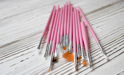 pink brush for nail on white wooden table, copy space