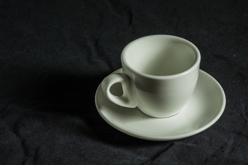  espresso coffee cup - white curved coffee cup with a thin porcelain pale for espresso coffee on a black background, original Italian design