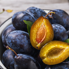 Full plate of ripe prune fruits on wooden table close-up © Sergey Chayko
