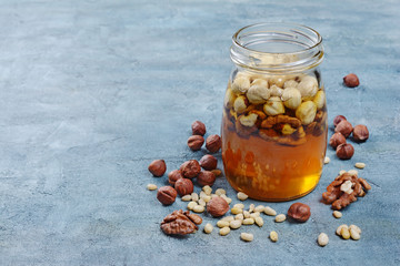Healthy mix of natural honey with different nuts in a jar