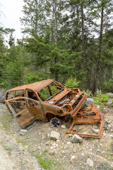 Rusty burnt car on the road side