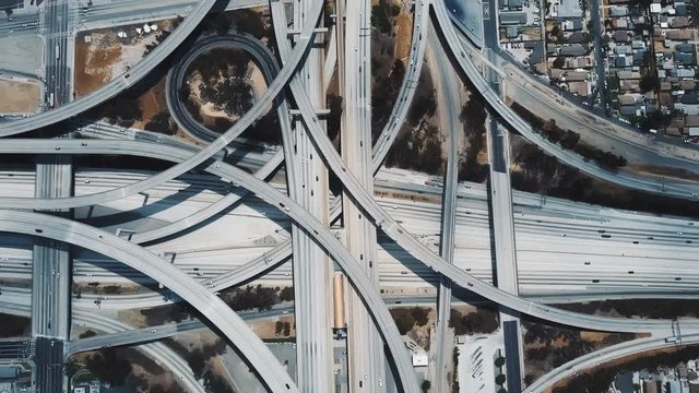Amazing aerial lockdown view of cars moving through large complex highway junction interchange in Los Angeles, USA.