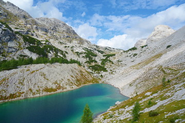 Mountain lake with turquoise water in Julian Alps (Jezero v Ledvicah) on a hiking trail called Seven lakes (Sedmera jezera), Triglav national park, Slovenia