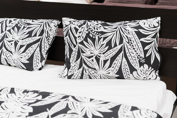 Close up of black and white Cushions pillows with leaf pattern on Bed