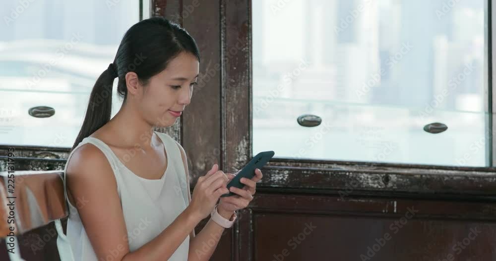 Wall mural woman use of smart phone for searching something on ferry