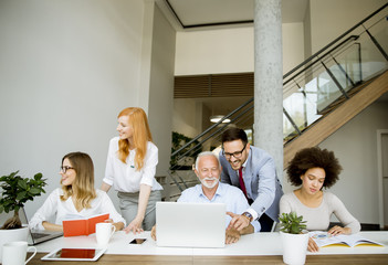 Obraz premium Joyful multiracial business team at work in modern office