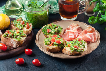 Bruschetta with fresh pesto, mozzarella and cherry tomatoes on a plate