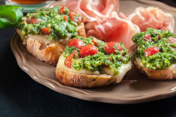 Bruschetta with fresh pesto, mozzarella and cherry tomatoes on a plate